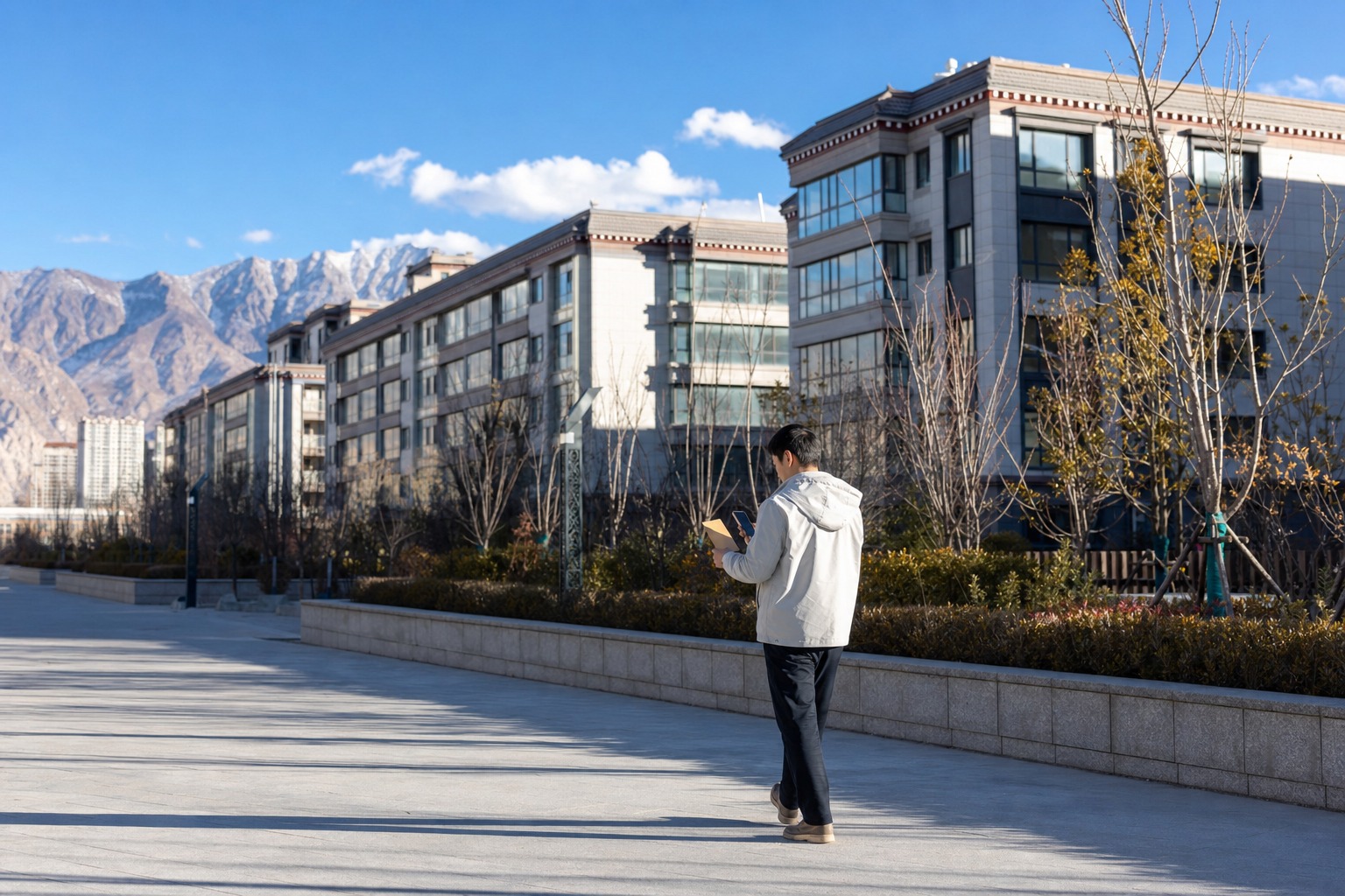 拉萨新建住宅外，购房人拿着信封和手机查看项目付款信息